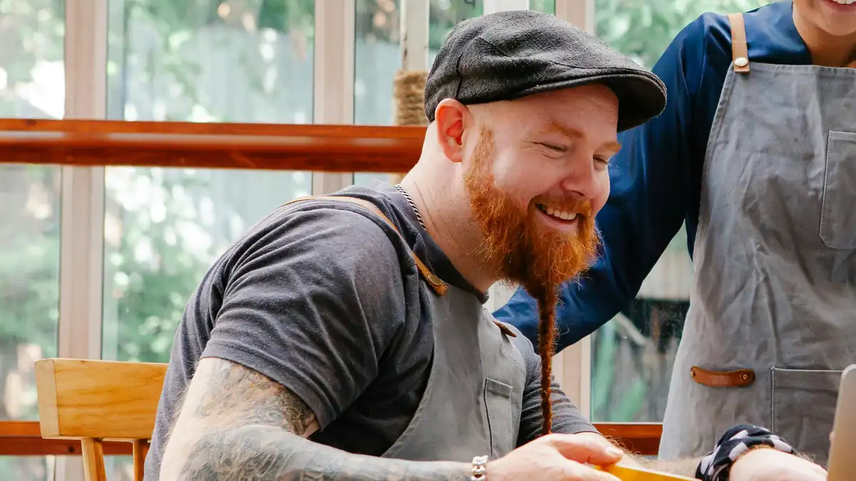 Cafe staff reviewing a laptop together at a table