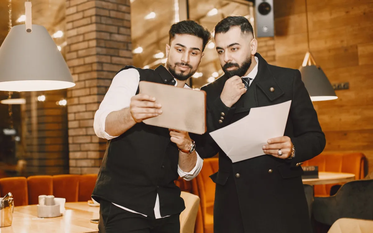Gérant de restaurant vérifiant un document de service avec un employé