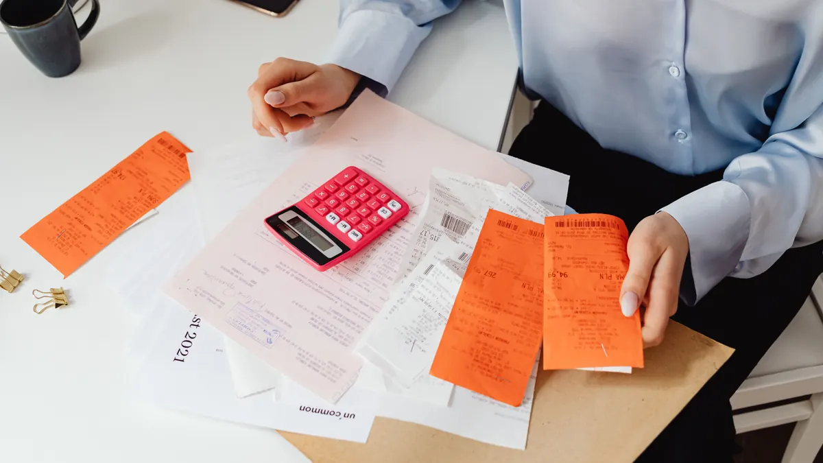 Manager checking receipts with a calculator before a tip pool payout