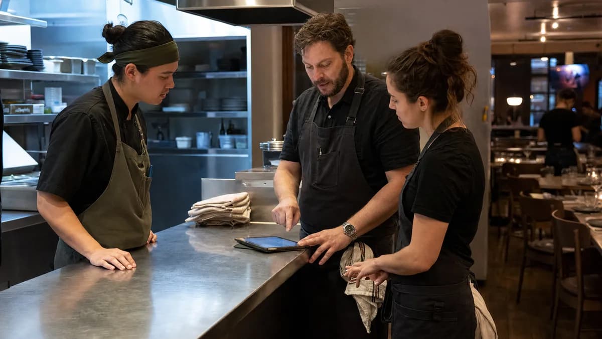 Restaurant team reviewing an operations handoff at the service pass