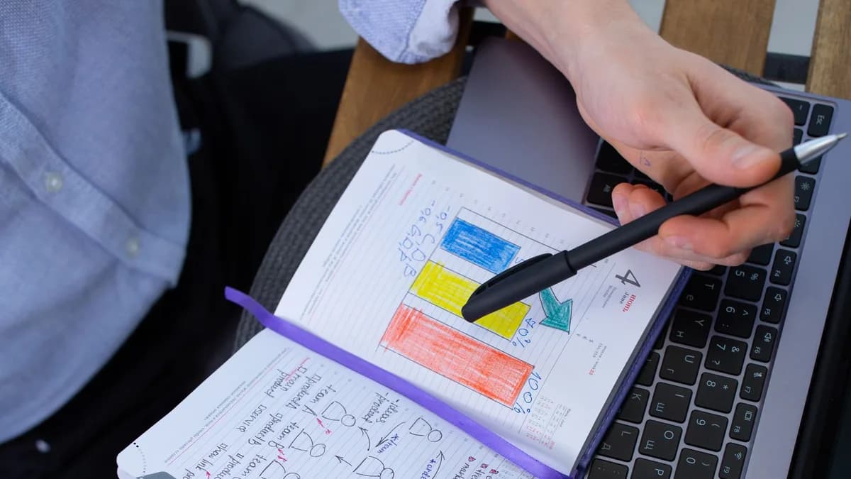 Manager reviewing color-coded notes beside a laptop before holiday payroll handoff
