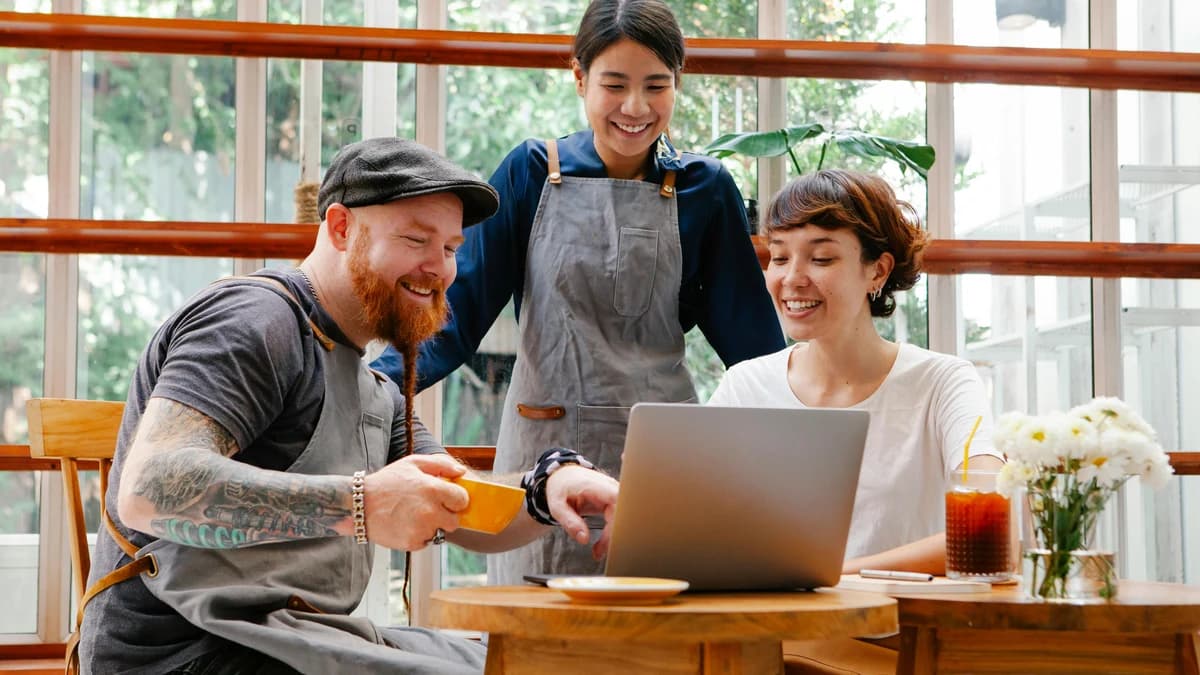 Cafe staff reviewing a laptop together at a table