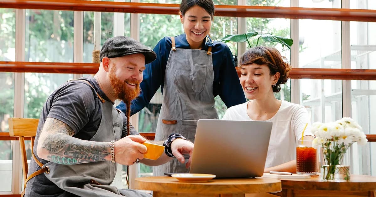Cafe team reviewing employee scheduling software on a laptop