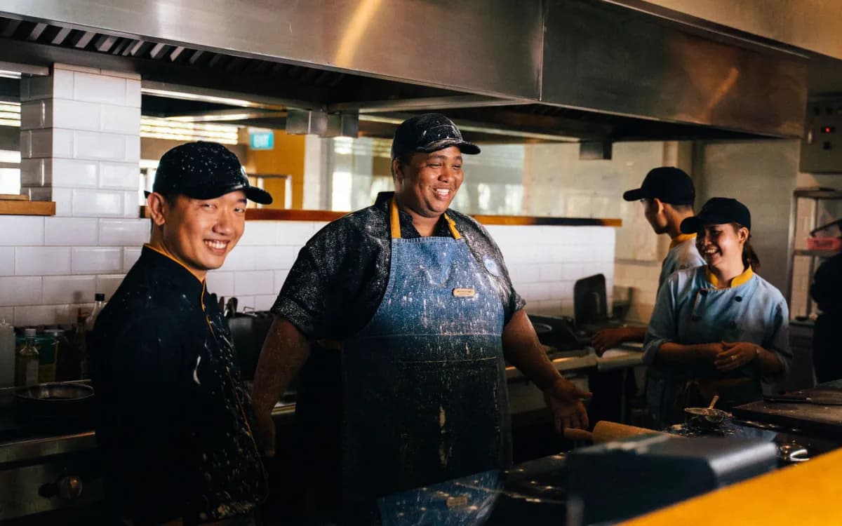 Restaurant kitchen team coordinating coverage during service