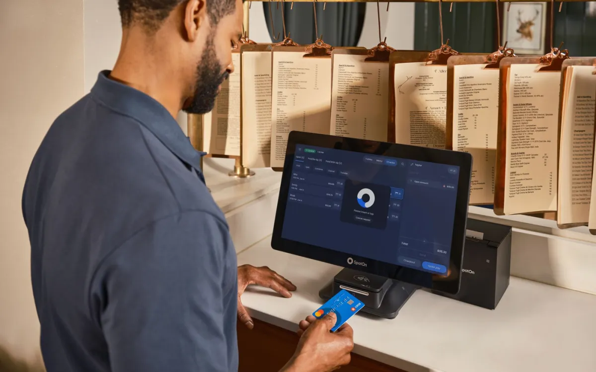 Restaurant employee checking the approved point-of-sale source for a tip-pooling policy