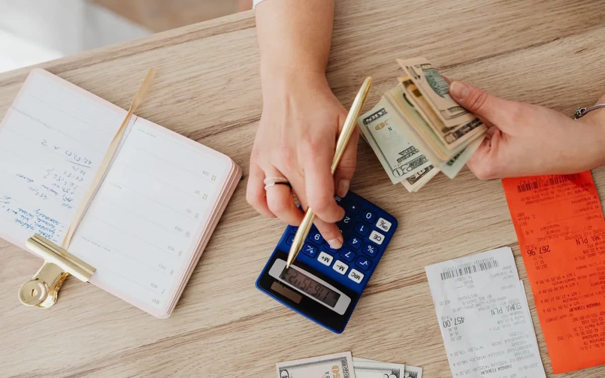 Hands checking receipts and calculator totals for an exact-cent tip allocation