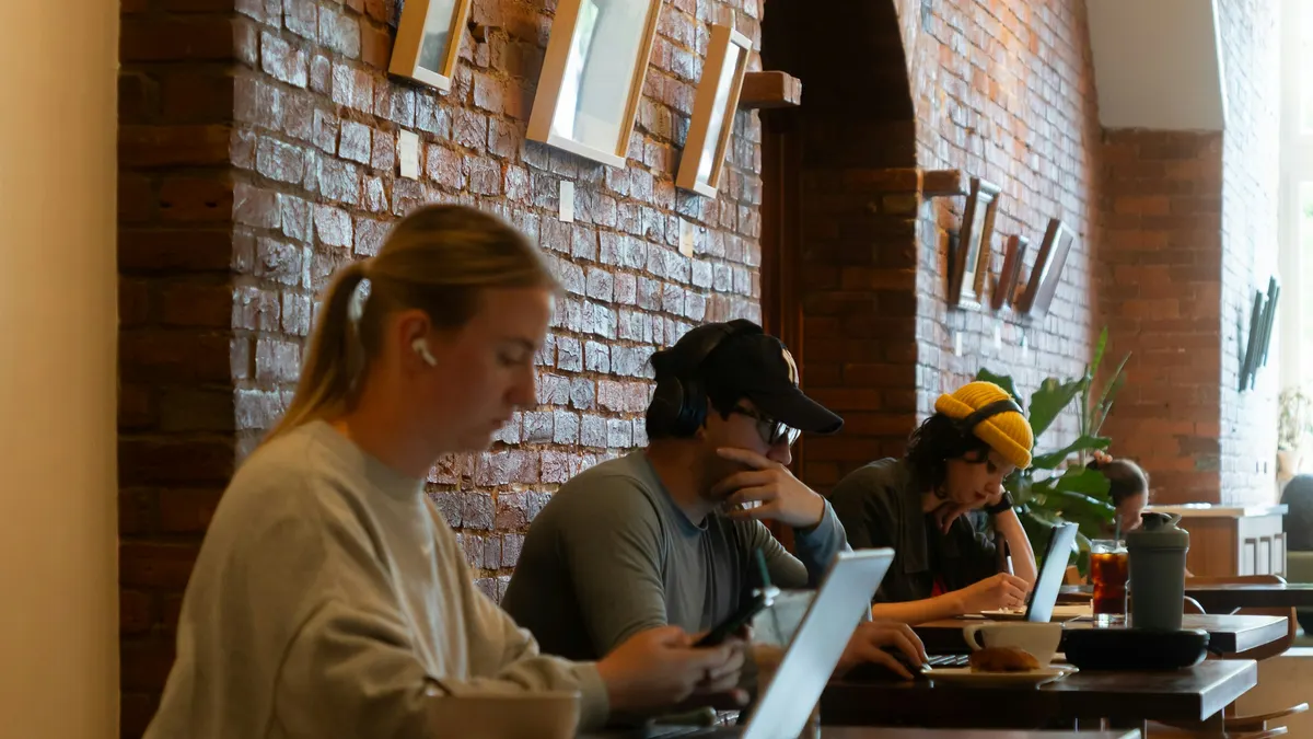 Canadian cafe manager comparing scheduling tools on a laptop